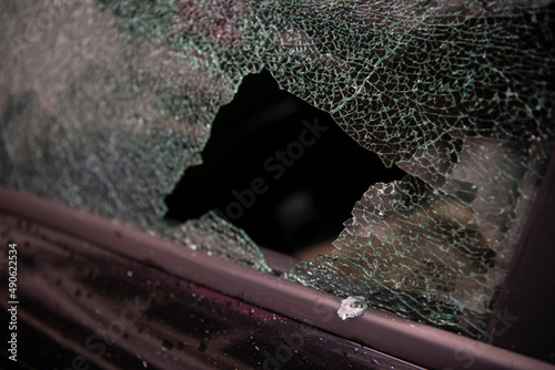 Broken window and abduction of things from a car. A criminal incident. Hacking the car. Broken left side window of a car.