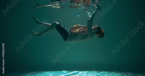 Depressed helpless young woman in business suit sinking underwater hits bottom. Emotional burnout concept slow motion.
