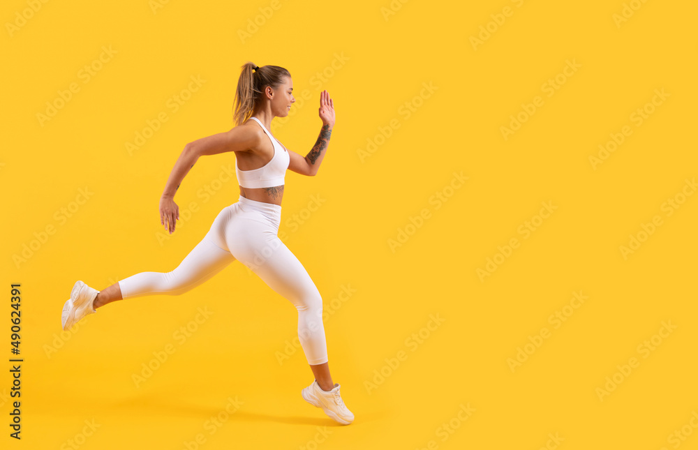 sport girl runner running on yellow background. copy space