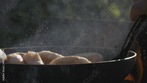 Pies in a pan. Creative. The dough is fried in a hot pan. The oil is boiling. Frying food in nature on an open fire photo