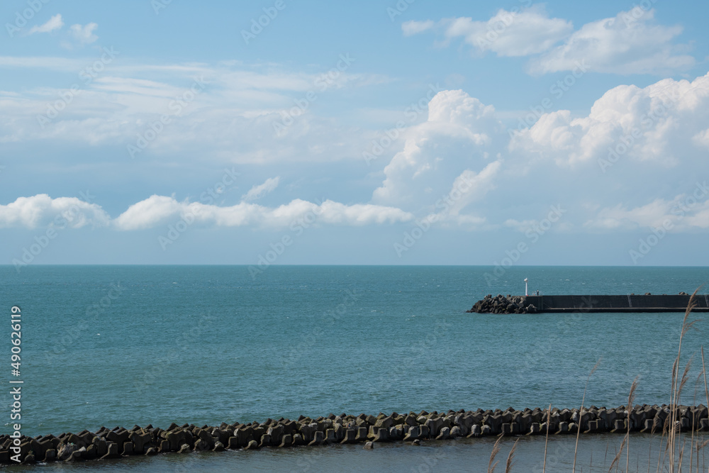 防波堤のある静かな青い海と青空
