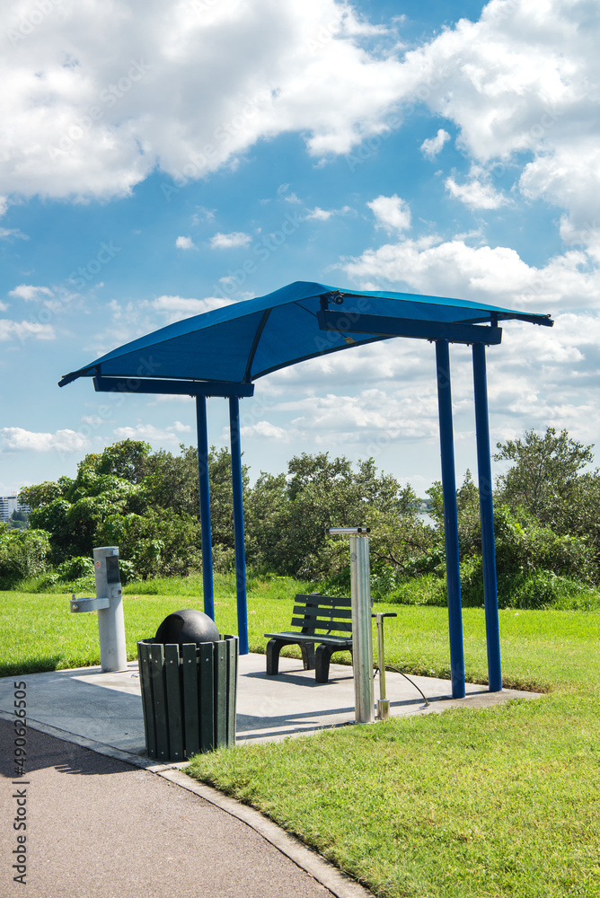 bus stop with a canopy and a drinker. green lawn and blue sky bus stop with a canopy and a drinker. green lawn and blue sky