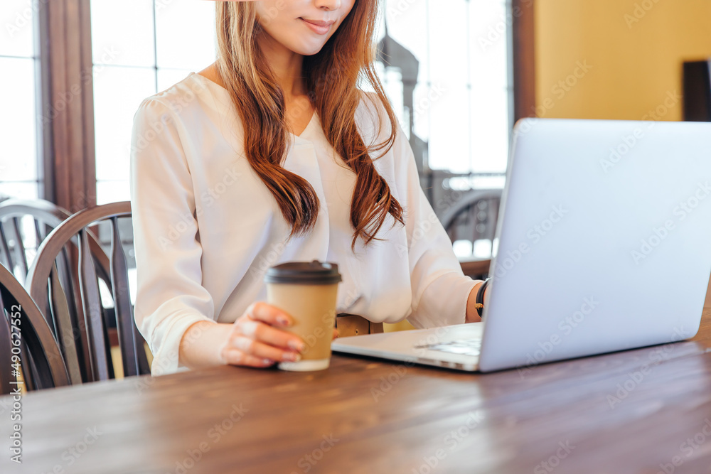 コーヒーを片手にPCを開く女性 office lady コーヒーを片手にPCを開く女性 office lady
