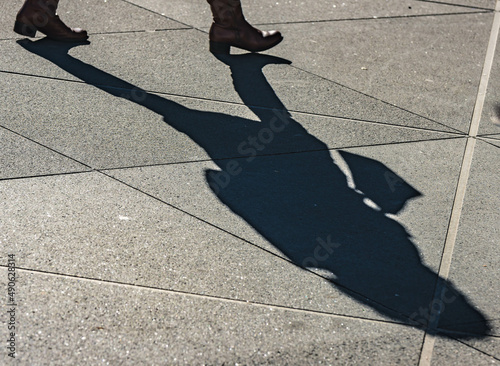 Abstract street photography, women shadow walking on a sidewalk, city life, texture backgrounds lifestyle photography.