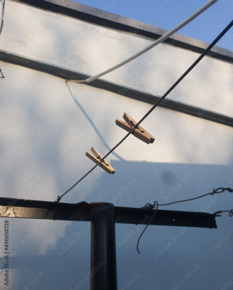 Two wooden clothespins are left outside hanging on the clothesline Two wooden clothespins are left outside hanging on the clothesline
