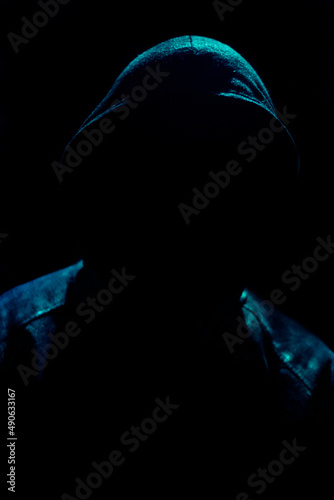 Obraz na plátně Dark and sinister silhouette on hooded figure on black background