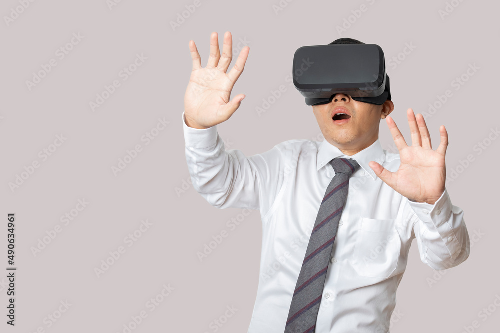 Studio portrait man wearing VR Headset isolated on gray background. Studio portrait man wearing VR Headset isolated on gray background.