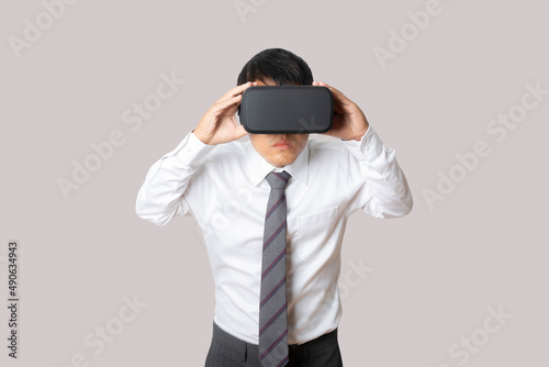 Studio portrait man wearing VR Headset isolated on gray background.