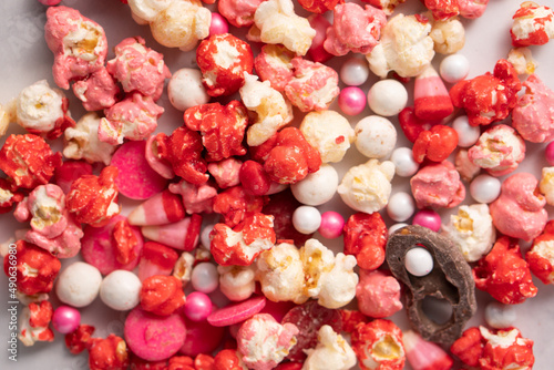 Colorful red and pink candied popcorn with mixed candies pile
