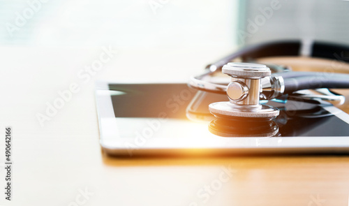 Digital tablet and stethoscope on table