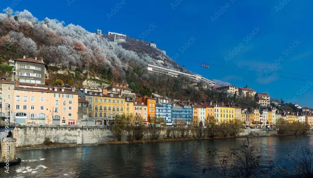 View of right bank of Isere river in Grenoble with cable car to Bastille, France