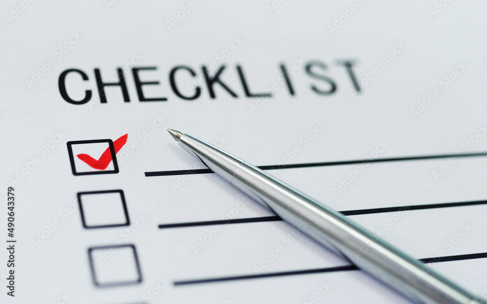 Checklist with checkmark and pen on paper Checklist with checkmark and pen on paper