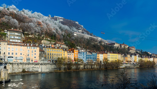View of right bank of Isere river in Grenoble with cable car to Bastille, France