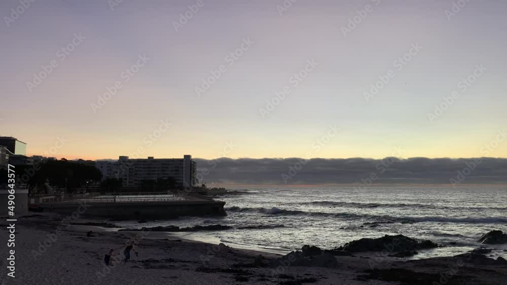 Sunset with people on the beach near public pool Sunset with people on the beach near public pool