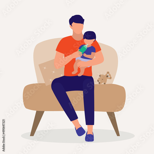 Father Sitting On A Sofa Chair While Bottle Feeding His Baby.