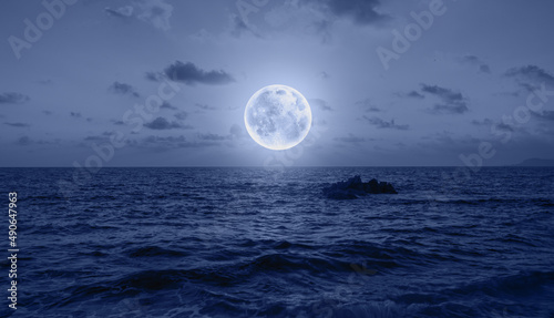 Moon rise in the clouds over the sea at night  "Elements of this image furnished by NASA © muratart