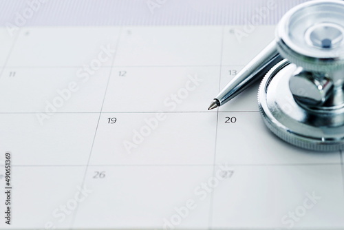 Stethoscope and pen over calendar