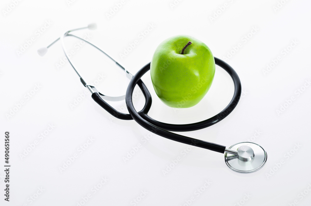 Green apple and stethoscope isolated on white background Green apple and stethoscope isolated on white background