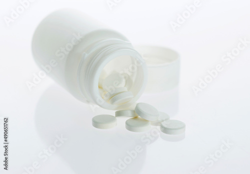 Pills and pill bottle isolated on white background