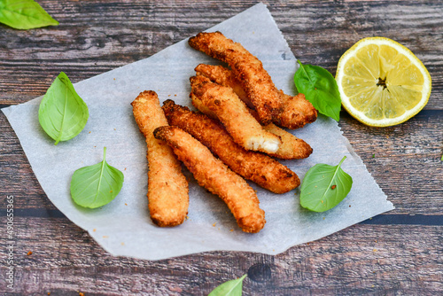  Crispy deep fried chicken strips and wedges potato. Breaded with cornflakes chicken breast fillets with chilly peppers and fresh basil on wooden rustic background