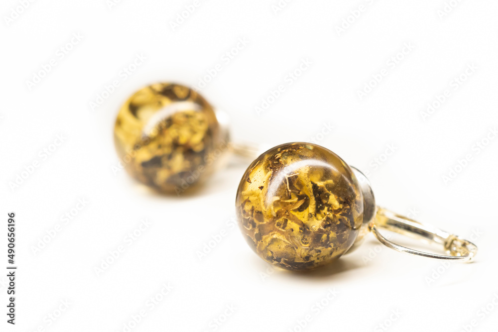 Organic lichen preserved in epoxy resin earrings. Natural handmade jewelry. Sphere ball shape, glossy surface. Selective focus on the details, object isolated on white background. Organic lichen preserved in epoxy resin earrings. Natural handmade jewelry. Sphere ball shape, glossy surface. Selective focus on the details, object isolated on white background.