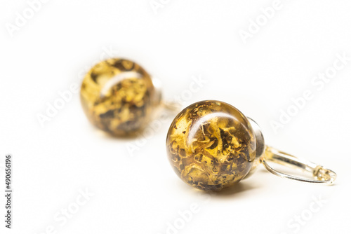 Organic lichen preserved in epoxy resin earrings. Natural handmade jewelry. Sphere ball shape, glossy surface. Selective focus on the details, object isolated on white background.