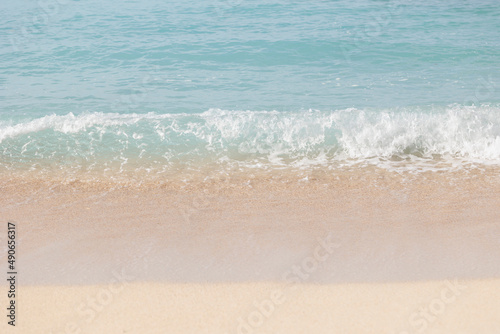 穏やかな波の明るいビーチ