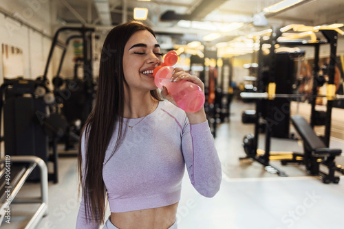 Fitness woman drinking water from bottle. Muscular young female at gym taking a break from workout. Shot of a young athlete drink water while at the gym.