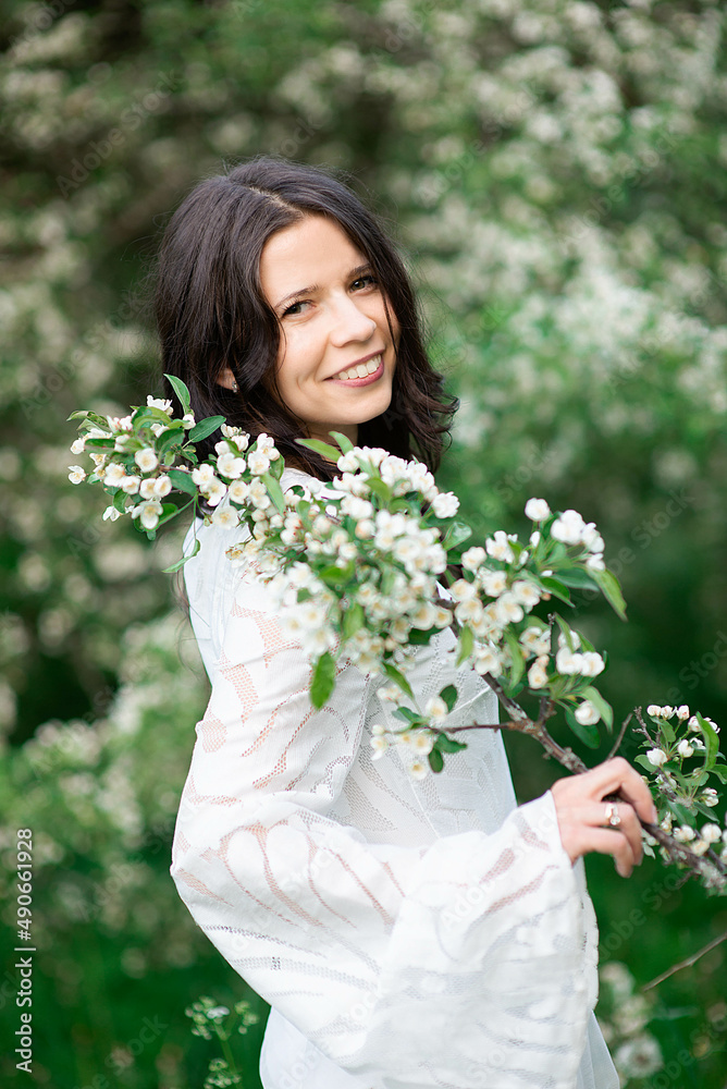 Portrait of a beautiful young woman in the park in the blooming branches at the summer or spring. Portrait of a beautiful young woman in the park in the blooming branches at the summer or spring.