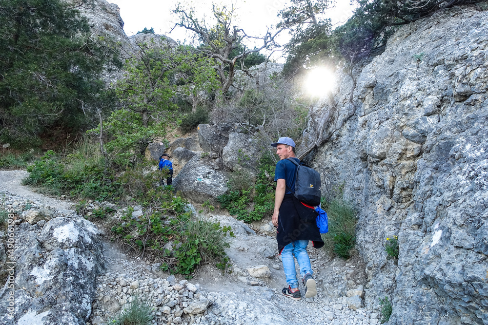 A man with a child on the background of the Crimean mountains on the Golitsyn trail. Crimea. 2021