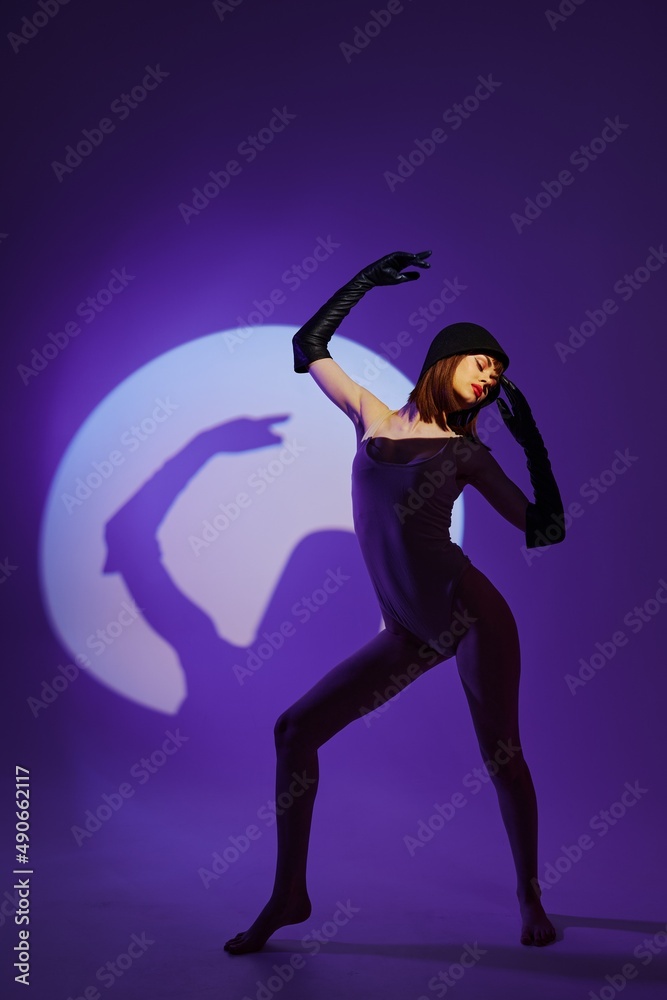 Fototapeta premium glamorous woman scene spotlight posing neon purple background unaltered