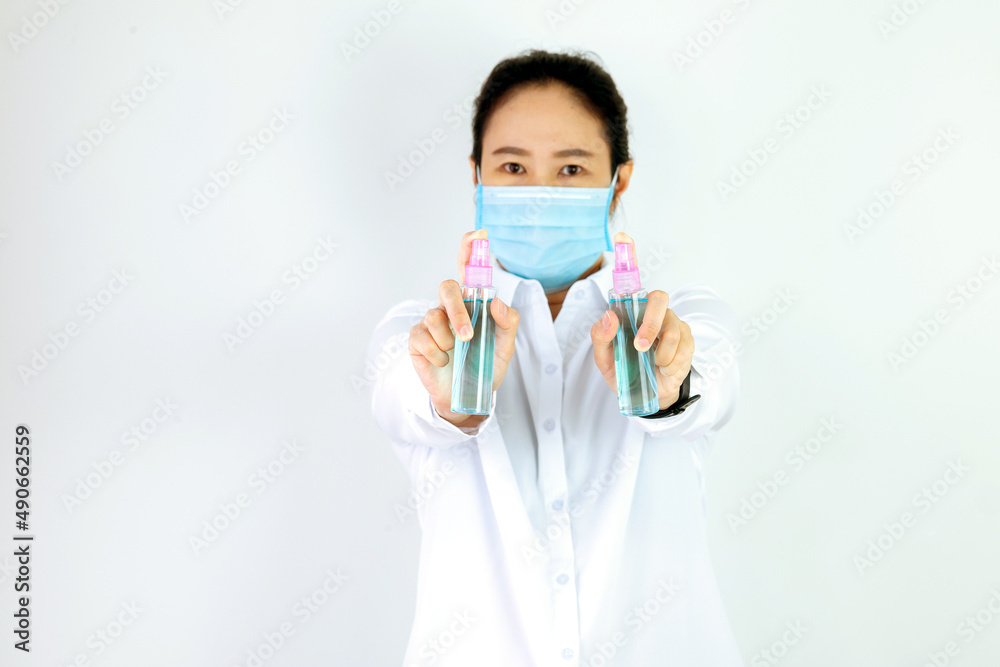 Asian woman are strengthening to overcome the virus by wearing a mask and carrying alcohol bottles for washing hands, cleaning or spraying infected items. Covid-19 Asian woman are strengthening to overcome the virus by wearing a mask and carrying alcohol bottles for washing hands, cleaning or spraying infected items. Covid-19