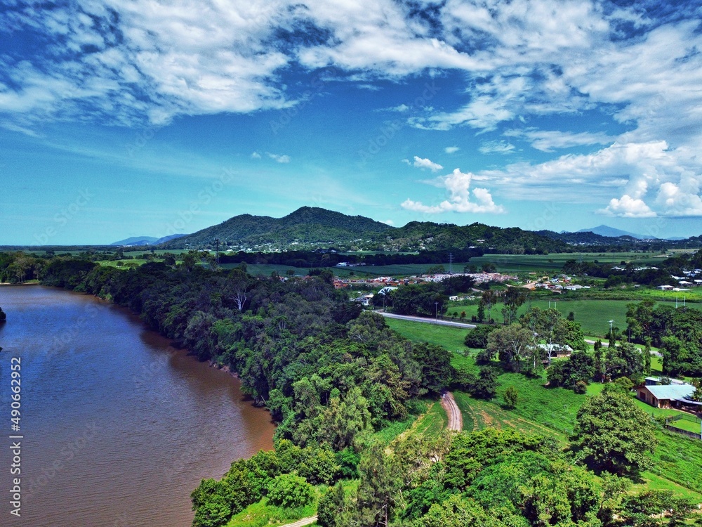 Aerial view of land river and mountain backdrop Aerial view of land river and mountain backdrop