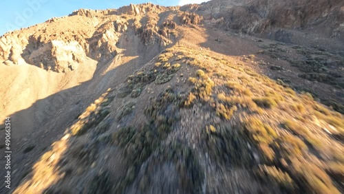 Cliff rock and mountain surfing with a FPV drone in a desert and moon like sandy and rocky landscape. Close flying in a dramtic rough nature park landscape. photo