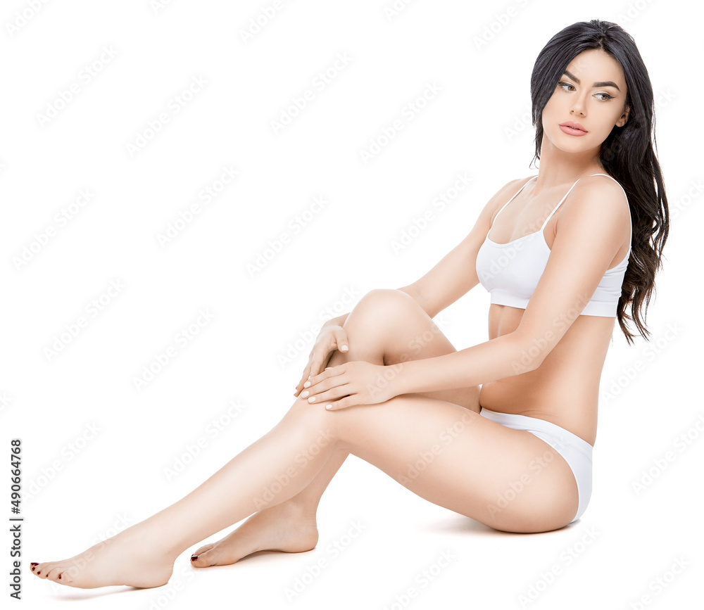 Fitness young woman with a beautiful body sitting on white background Fitness young woman with a beautiful body sitting on white background