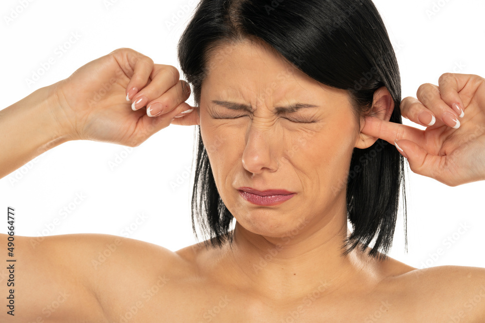 Portrait of disturbed young woman shouting while putting fingers on the ears
