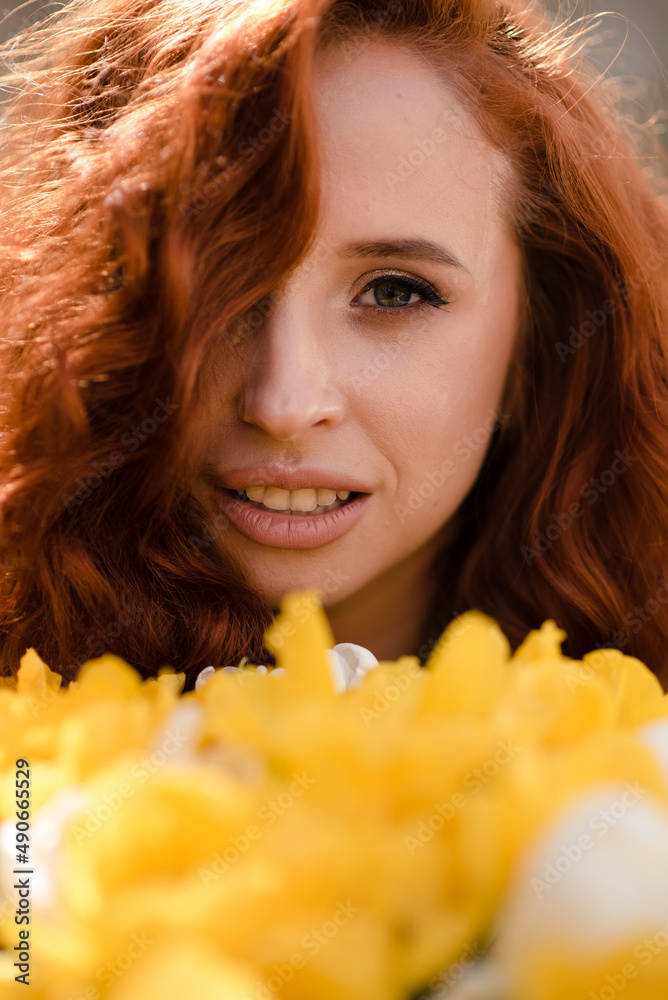 Stylish woman with red curly hair with a bouquet of yellow tulips Stylish woman with red curly hair with a bouquet of yellow tulips