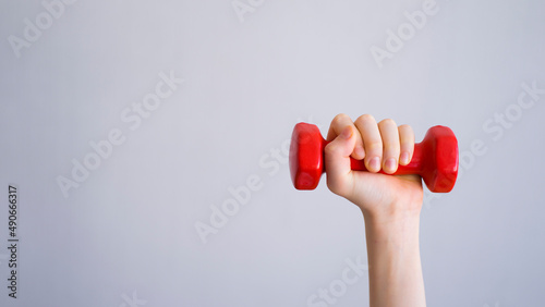 Hand holding a red dumbbell