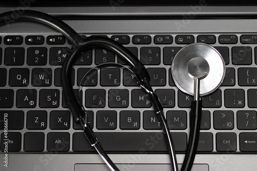 Medical stethoscope on laptop keyboard. Artificial intelligence based diagnostics, e-health concept, close-up