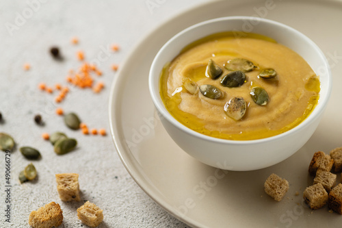cream soup vegetarian from lentils and champignons on a light background with seeds and croutons