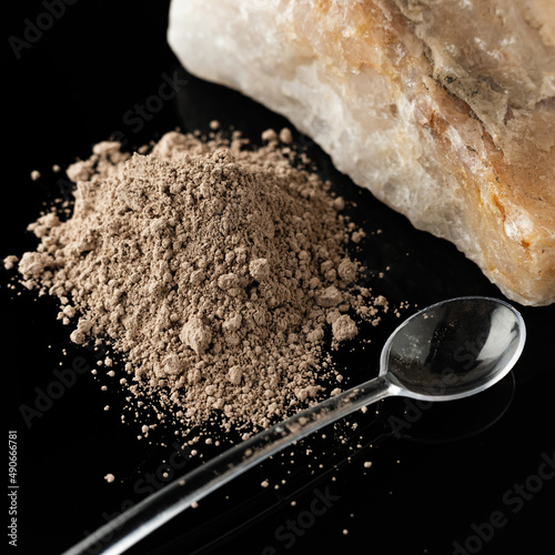 Mineral sorbent in powder on a black background, healthy lifestyle concept, close-up photo