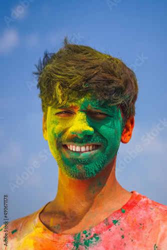 Portrait of a boy with his face covered in holi colors. joy of playing holi. Holi and festival concept.