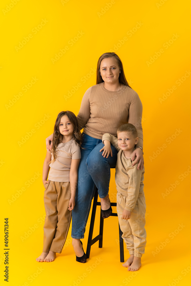 Children are standing next to their mother and looking at the camera Children are standing next to their mother and looking at the camera