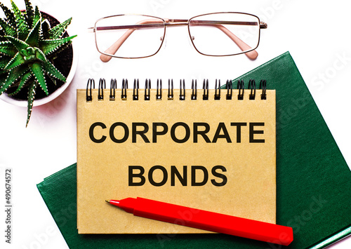 On a light background, business accessories and a brown notebook with the inscription CORPORATE BONDS. photo