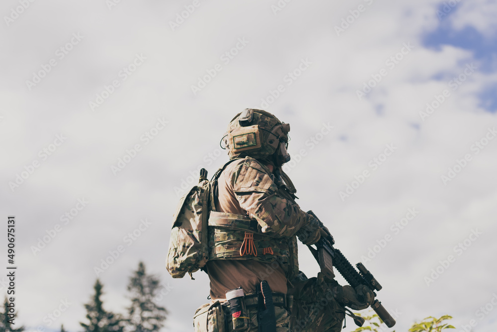 War concept. A bearded soldier in a special forces uniform fighting an enemy in a forest area. Selective focus War concept. A bearded soldier in a special forces uniform fighting an enemy in a forest area. Selective focus