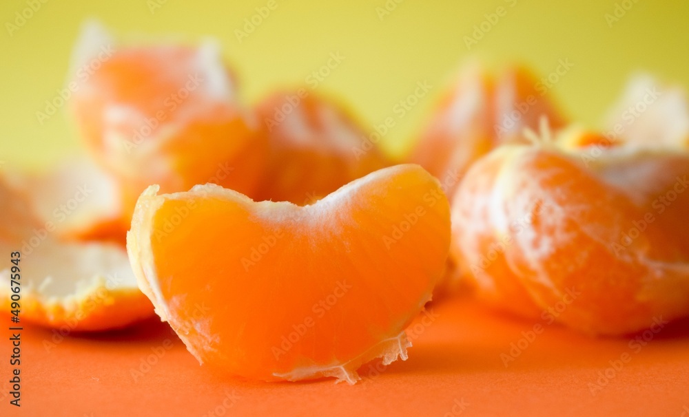 A slice of tangerine on an orange background A slice of tangerine on an orange background