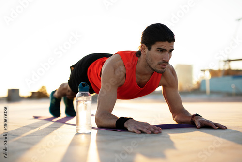 Young muscle man training outside. Fit handsome man doing exercise