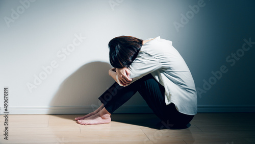精神障害を患っている若い女性が膝を抱えている