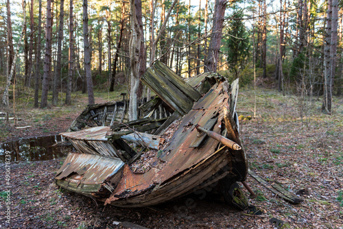 Fototapeta Naklejka Na Ścianę i Meble -  Old abandoned wooden fishing boat in the forest. Boat cemetery.
