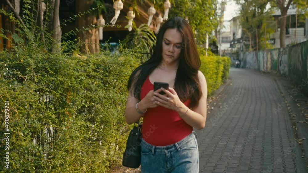 a beautiful trans woman chatting while walking down the street